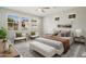 Staged primary bedroom features neutral colors, large windows and ceiling fan at 20644 W Mariposa St, Buckeye, AZ 85396