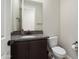 The powder room features a granite-topped vanity, a decorative mirror, and a toilet at 20644 W Mariposa St, Buckeye, AZ 85396