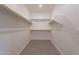 Empty walk-in closet with a gray tile floor, white walls, and wood shelves at 20644 W Mariposa St, Buckeye, AZ 85396