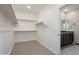 Walk-in closet with shelving racks, tile flooring, and an open entrance to the ensuite bathroom at 20644 W Mariposa St, Buckeye, AZ 85396