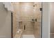 Walk-in shower with neutral tile, glass door, built-in shelves, and bronze shower fixtures at 20644 W Mariposa St, Buckeye, AZ 85396