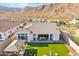 Aerial view of the backyard with a covered patio, artificial turf, playground, and desert mountain views at 21391 W Mariposa St, Buckeye, AZ 85396