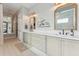 Bathroom features double sinks, gold mirror frames and a neutral color palette at 21391 W Mariposa St, Buckeye, AZ 85396