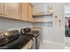 Functional laundry room boasts modern appliances, stylish shelves, and ample space for all your laundry needs at 21391 W Mariposa St, Buckeye, AZ 85396