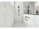 Modern shower with white marble-style tile and built-in shelving at 21391 W Mariposa St, Buckeye, AZ 85396
