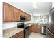 Well-lit kitchen features granite countertops, stainless steel appliances, and dark wood cabinetry at 2174 W Kristina Ave, San Tan Valley, AZ 85144