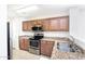 Functional kitchen featuring warm-toned cabinets, stainless-steel appliances, and tile flooring at 2174 W Kristina Ave, San Tan Valley, AZ 85144
