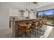 Contemporary kitchen with sleek cabinets, waterfall island, pendant lighting, and an inviting breakfast bar at 24863 N 103Rd Way, Scottsdale, AZ 85255