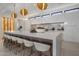 Kitchen with long quartz countertop island, white cabinets, pendant lighting, and seating for six at 24863 N 103Rd Way, Scottsdale, AZ 85255