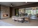 Cozy outdoor patio featuring a stone fireplace and comfortable dining area with views into the home at 24863 N 103Rd Way, Scottsdale, AZ 85255