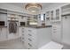 Spacious walk-in closet with custom shelving, drawers, and a central island with granite countertop at 24863 N 103Rd Way, Scottsdale, AZ 85255