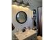 Bright bathroom featuring a decorative vanity with a dark faucet and stylish lighting fixture at 2501 E Pebble Beach Dr, Tempe, AZ 85282