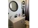 Well-lit bathroom featuring a decorative vanity with dark faucet and round mirror at 2501 E Pebble Beach Dr, Tempe, AZ 85282