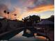 Backyard pool area with cabana, basketball hoop, and palm trees, beautifully illuminated at sunset at 2501 E Pebble Beach Dr, Tempe, AZ 85282