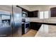 Close up of a kitchen boasting stainless steel appliances and dark wood cabinets at 25602 W Coles Rd, Buckeye, AZ 85326