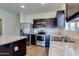 A pristine kitchen featuring stainless steel appliances, granite countertops, and dark wood cabinetry at 25602 W Coles Rd, Buckeye, AZ 85326
