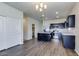 Open floor plan showcasing a kitchen with a stainless-steel fridge, center island and dark cabinetry at 25602 W Coles Rd, Buckeye, AZ 85326