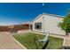 Backyard featuring an artificial turf area, a seating area, and desert landscaping offers a relaxing outdoor retreat at 25915 W Tina Ln, Buckeye, AZ 85396