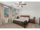 Stylish bedroom boasts modern ceiling fan, king-size bed, and natural light from the large windows at 25915 W Tina Ln, Buckeye, AZ 85396