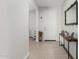 Bright entryway with neutral walls, wood-look tile floors, and a view into a home office space at 25915 W Tina Ln, Buckeye, AZ 85396