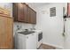 This laundry room features a washer, dryer, upper cabinets, and tile flooring at 25915 W Tina Ln, Buckeye, AZ 85396