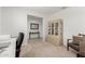 Bright home office featuring neutral carpet, seating, desk, shelving, and built-in storage cabinet at 25915 W Tina Ln, Buckeye, AZ 85396
