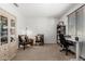 Bright home office with neutral carpet, seating, desk, shelving, and built-in storage cabinet at 25915 W Tina Ln, Buckeye, AZ 85396