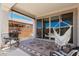 Relaxing covered patio with a hammock swing, chairs, and outdoor grill, perfect for entertaining at 25915 W Tina Ln, Buckeye, AZ 85396