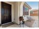 Cozy front porch with a chair, decor, and a decorative door, creating an inviting entrance at 25915 W Tina Ln, Buckeye, AZ 85396