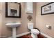 Powder room with a pedestal sink, decorative mirror, updated fixtures, and a modern toilet at 3065 E Harvard Ave, Gilbert, AZ 85234