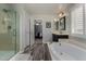 Bathroom with dual sinks, a soaking tub, a glass enclosed shower and wood-look floors at 3065 E Harvard Ave, Gilbert, AZ 85234