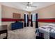 Bedroom with blue dresser, red stripe accent wall, and modern ceiling fan at 3065 E Harvard Ave, Gilbert, AZ 85234