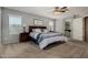 Bright bedroom with ceiling fan, plush carpet, and an open doorway to the attached bathroom at 3065 E Harvard Ave, Gilbert, AZ 85234