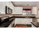 Gourmet kitchen with stainless steel appliances, granite countertops, and white cabinetry at 3065 E Harvard Ave, Gilbert, AZ 85234