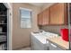 Laundry room featuring washer, dryer, utility sink, storage cabinets and a bright window at 3065 E Harvard Ave, Gilbert, AZ 85234