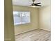 Bright bedroom with wood-look vinyl floors, a ceiling fan, and a window for natural light at 3121 W Laurie Ln, Phoenix, AZ 85051
