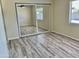 Bedroom featuring wood-look vinyl floors and a closet with mirrored doors, and window at 3121 W Laurie Ln, Phoenix, AZ 85051