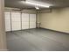Clean garage with a white garage door and painted gray flooring at 3121 W Laurie Ln, Phoenix, AZ 85051