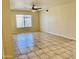 Spacious living area features neutral walls, tiled flooring, a window, and a ceiling fan at 3121 W Laurie Ln, Phoenix, AZ 85051