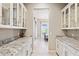 A butler's pantry features white cabinetry, granite countertops, and a view into the dining room at 31320 N 54Th Pl, Cave Creek, AZ 85331