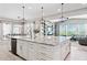 Open kitchen with an island, white cabinets, stainless appliances and an adjoined living room at 31320 N 54Th Pl, Cave Creek, AZ 85331