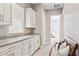 A modern mud room with white cabinets, granite countertops, a bench and coat rack at 31320 N 54Th Pl, Cave Creek, AZ 85331