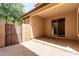 Back patio featuring stucco exterior, partial shade, and gate access to the side yard at 3449 E Sheffield Rd, Gilbert, AZ 85296