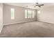 Expansive bonus room with plush carpeting, ceiling fan, and natural lighting from multiple windows at 3449 E Sheffield Rd, Gilbert, AZ 85296