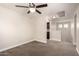Neutral bonus room with ceiling fan, natural light, and a partial view of the kitchen at 3449 E Sheffield Rd, Gilbert, AZ 85296