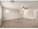 Large carpeted bonus room featuring a ceiling fan, neutral walls, and natural lighting from multiple windows at 3449 E Sheffield Rd, Gilbert, AZ 85296
