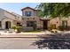 A tan two-story home features manicured landscaping, and a welcoming facade at 3449 E Sheffield Rd, Gilbert, AZ 85296