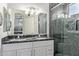 Bathroom featuring double sinks, black marble countertop, and walk-in shower with marble tiling at 3668 E Derringer Way, Gilbert, AZ 85297
