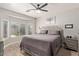 Spacious bedroom with bay window, wood-look floors, ceiling fan, and neutral gray decor at 3668 E Derringer Way, Gilbert, AZ 85297