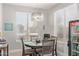 Cozy dining area with a round table, modern light fixture, and natural light from the window at 3668 E Derringer Way, Gilbert, AZ 85297